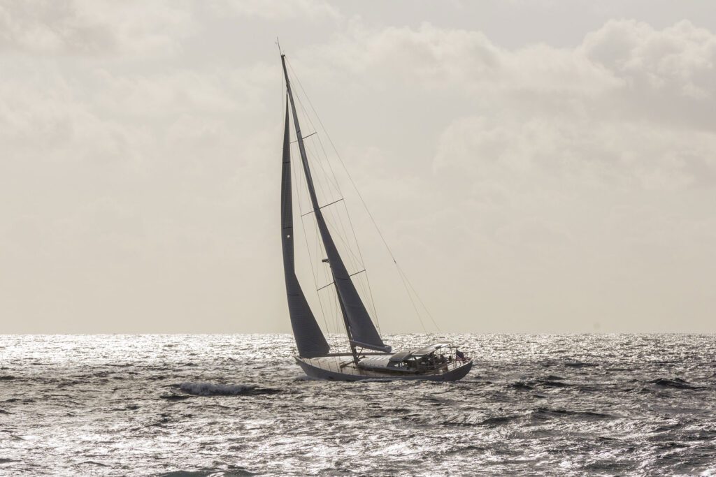 A sepia toned image of a large sailing yacht heeling on a choppy ocean.