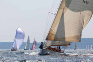 A photo of sailboat Anna heading downwind amongst many other colorful boats.